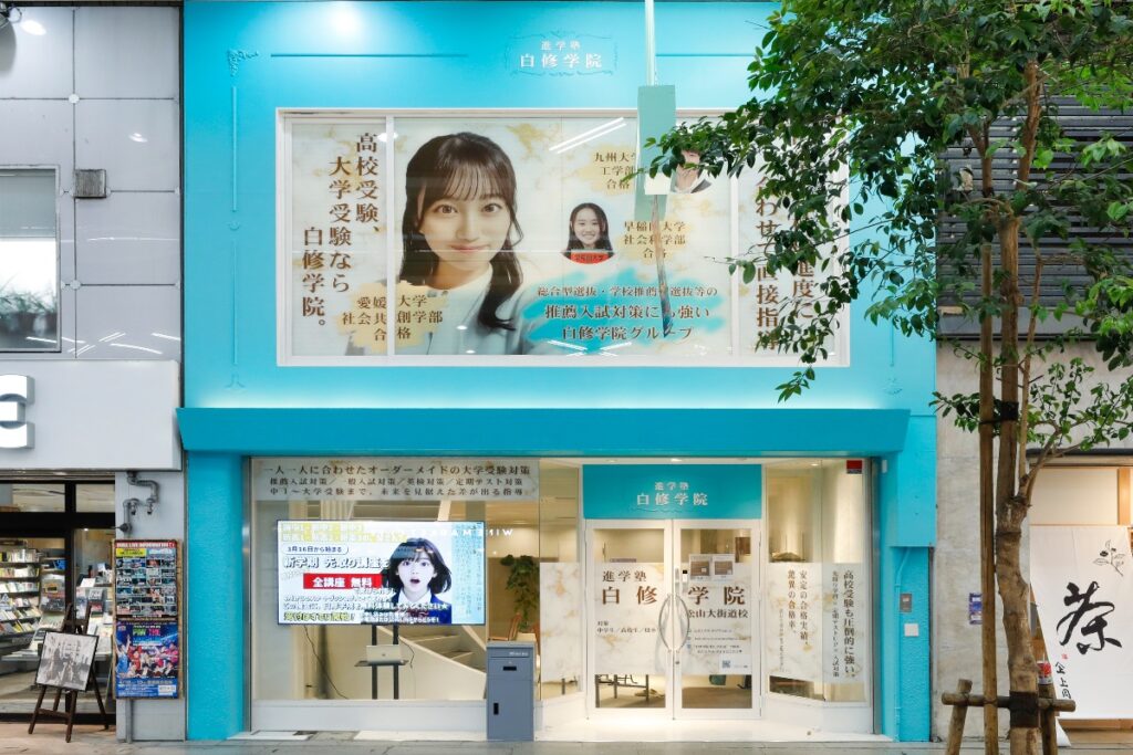 白修学院 松山大街道校の水色の外観と正面入口